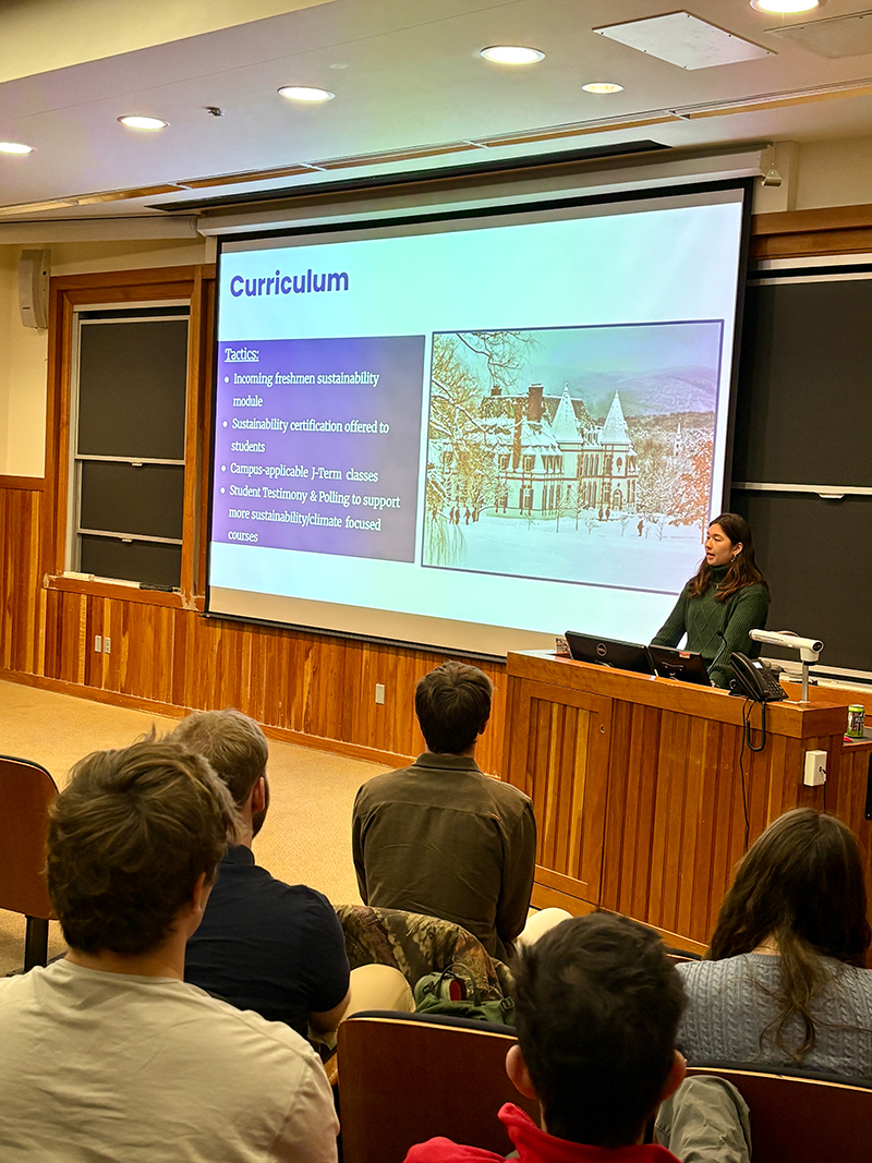 A student gives a presentation at a lectern in a classroom.