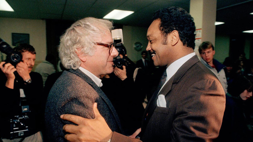 Bernie Sanders and Jesse Jackson shake hands at a campaign event.