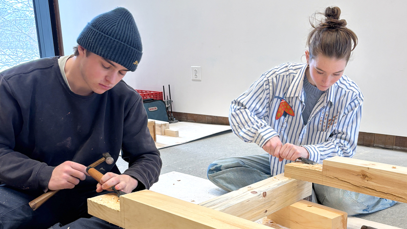 Students use chisels and hammers on a woodworking project.