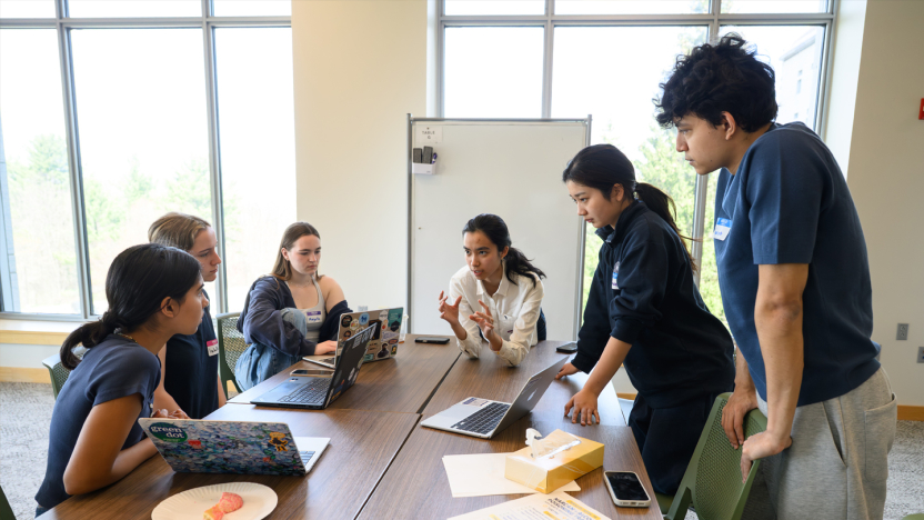 Students discuss their project around a table at DataFest.