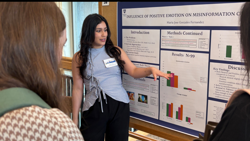 A student presents research findings during a poster session.