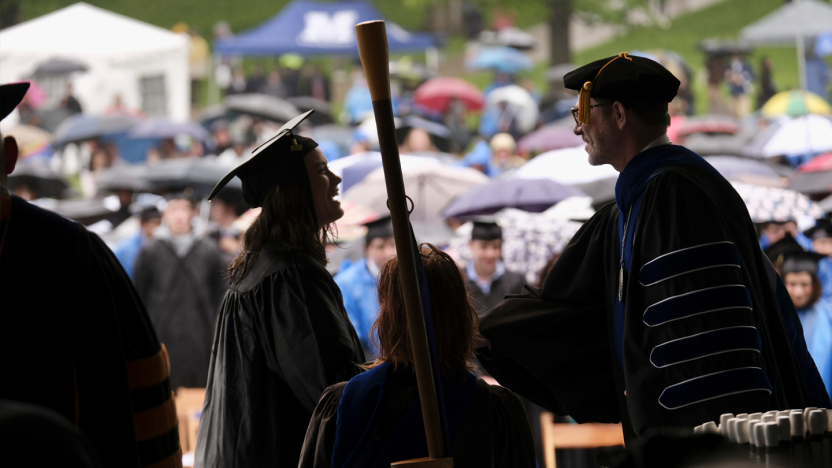 President Ian Baucom shakes hands with a new graduate at Commencement.