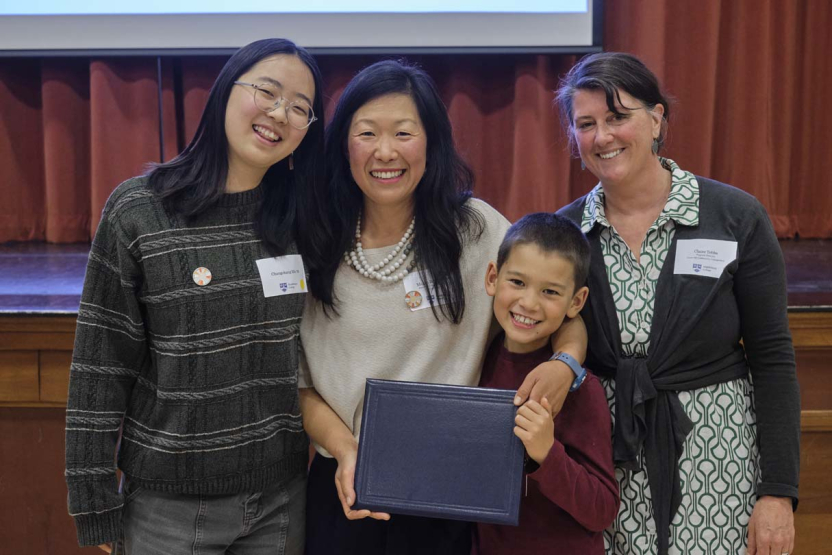 Four people pose for a photo during an awards ceremony.