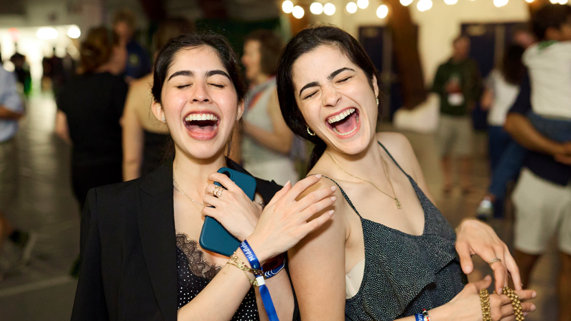 Two Reunion attendees dance and smile with their eyes closed.