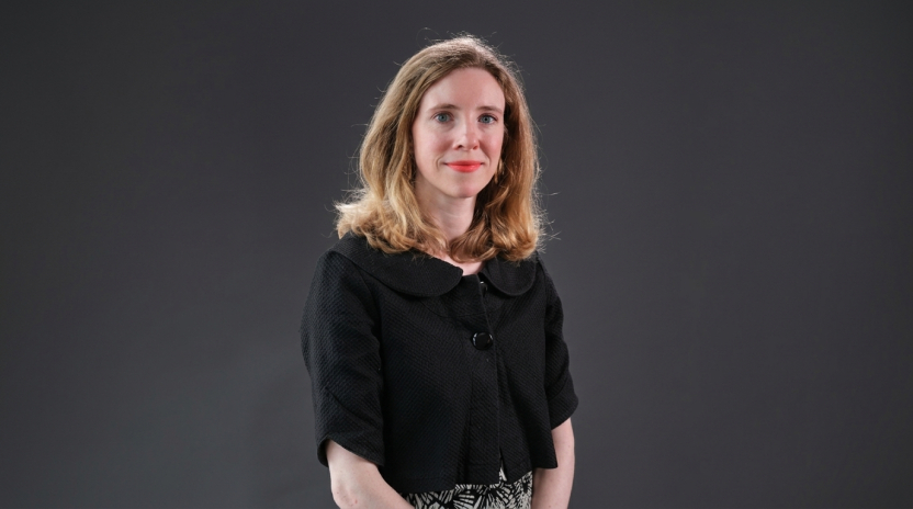 A professor wearing a black top smiles at the camera.