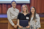 Three people pose for a photo at an awards ceremony.