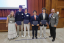 A group of students and staff members pose for a photo at an awards ceremony.