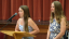 Two students stand at a podium to deliver remarks at a ceremony.