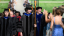 Faculty in academic regalia process outdoors to convocation ceremony