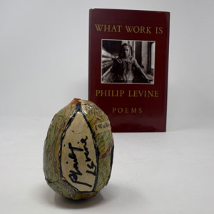 Philip Levine signature on wooden egg with book in background