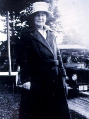 Willa Cather standing with car in background