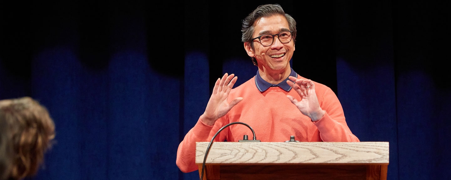 Facutly member Joseph O. Legaspi reads at the podium in the Little Theater on the Bread Loaf campus.