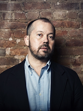 Alexander Chee in front of brick wall