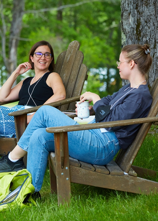 two people laughing in chairs outside