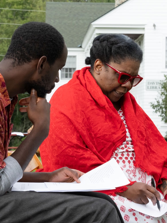Faculty member Vievee Francis and a student discuss a manuscript while sitting near the library on the Bread Loaf campus.